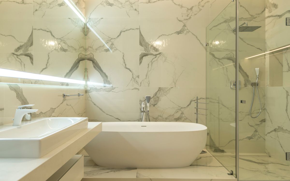 Salle de bains en marbre calacatta avec baignoire îlot et douche vitrée
